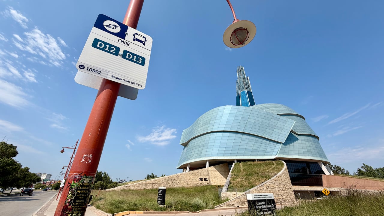 A sign indicated a bus stop, with a large building in the background