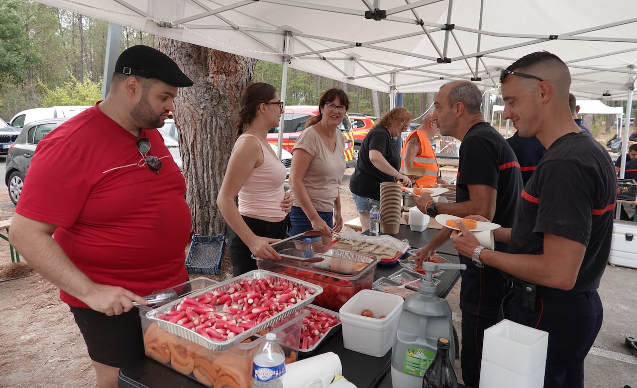 People serve meals outside.