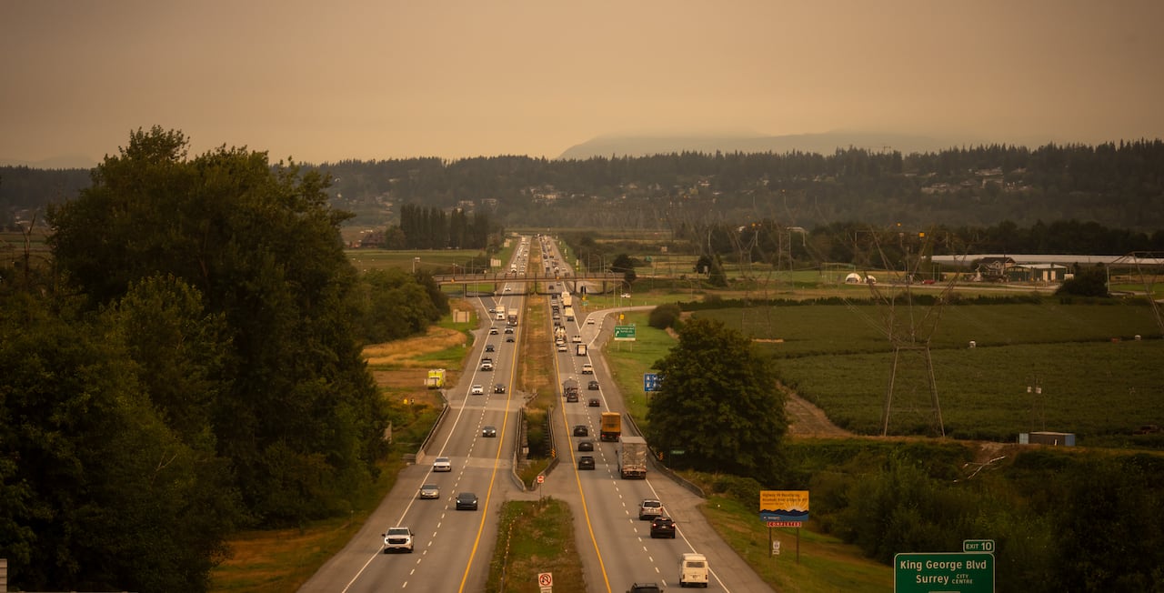 An overhead shot of a highway with visibly orange skies.
