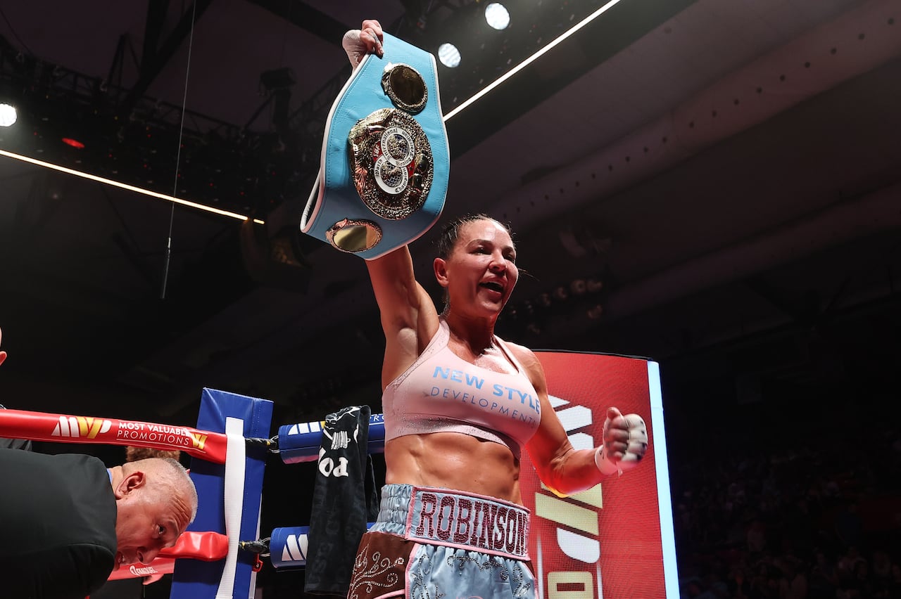 A boxer shows her championship belt.