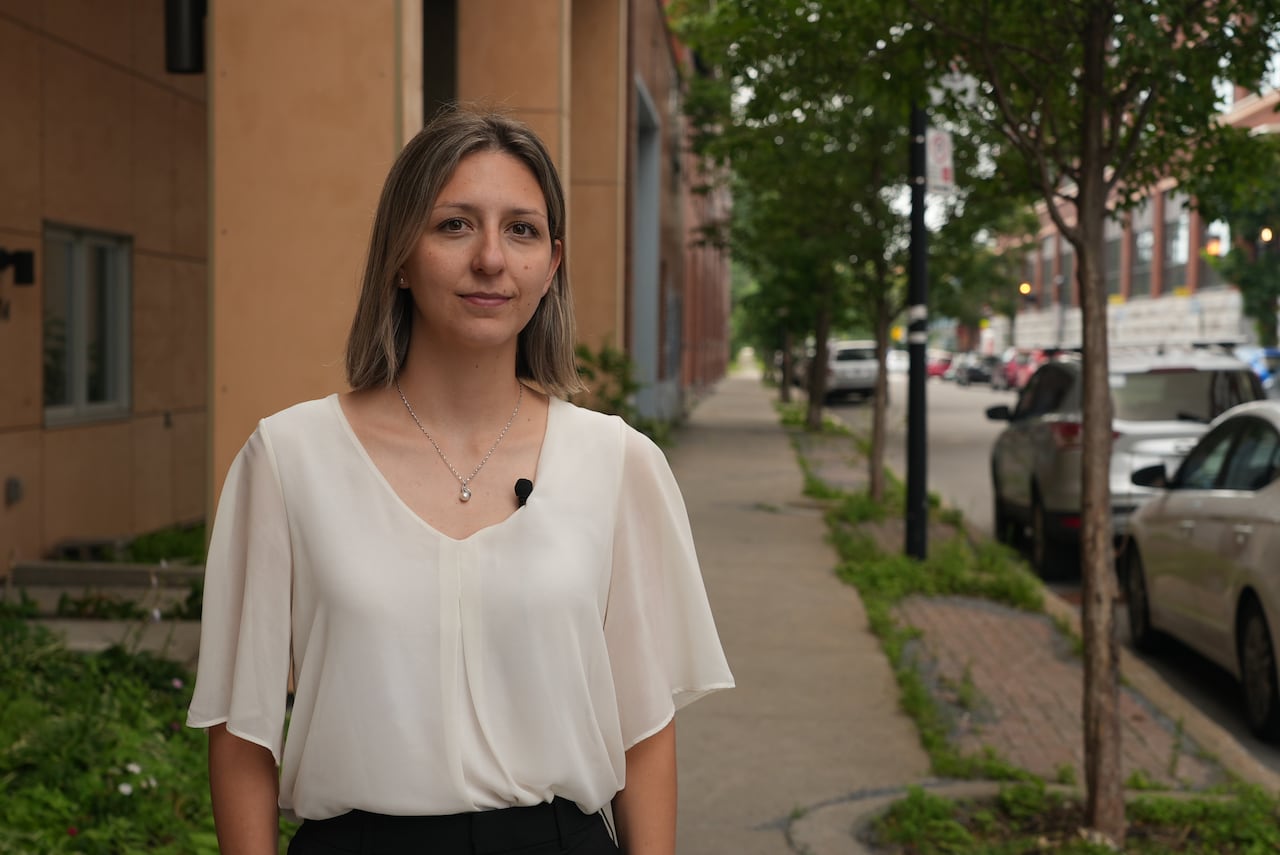 woman in a white shirt stands outside of her office in Montreal