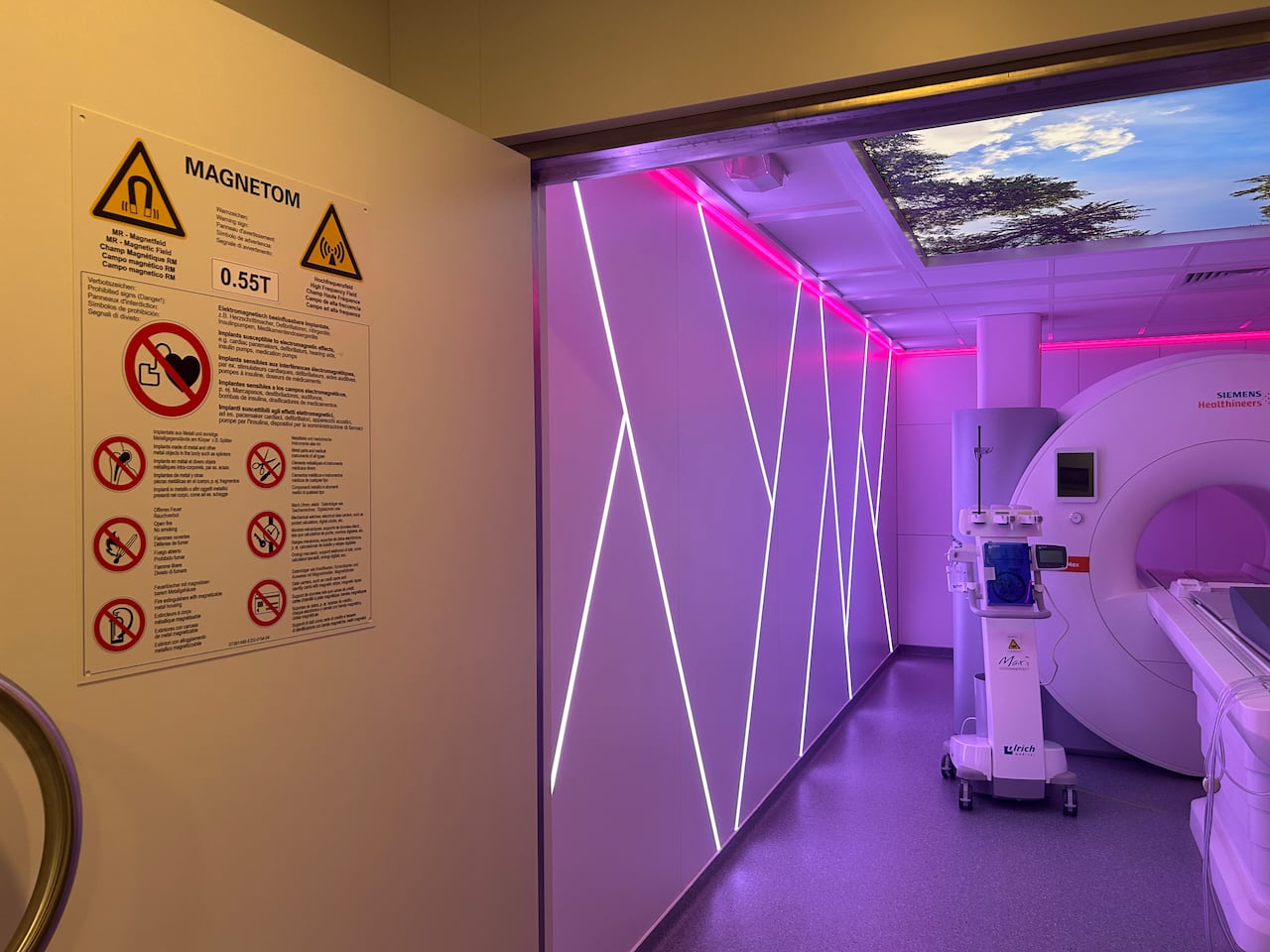 An MRI machine is seen in a room glowing purple.