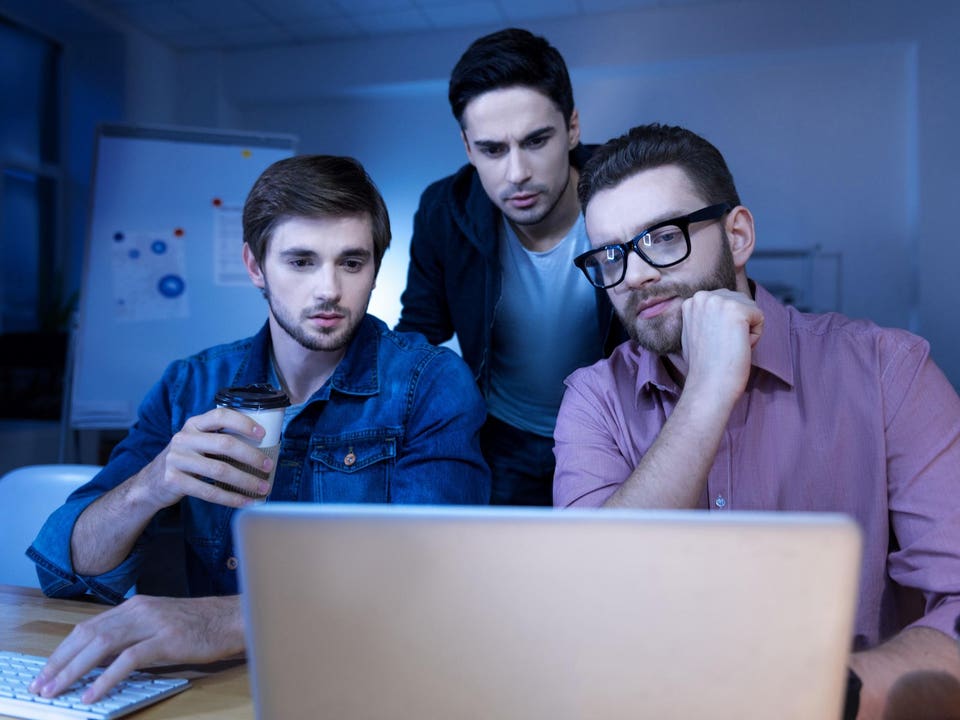 Handsome intelligent men looking at the laptop screen