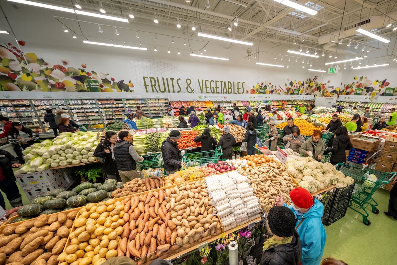 Shoppers mill about yams and other tubers.