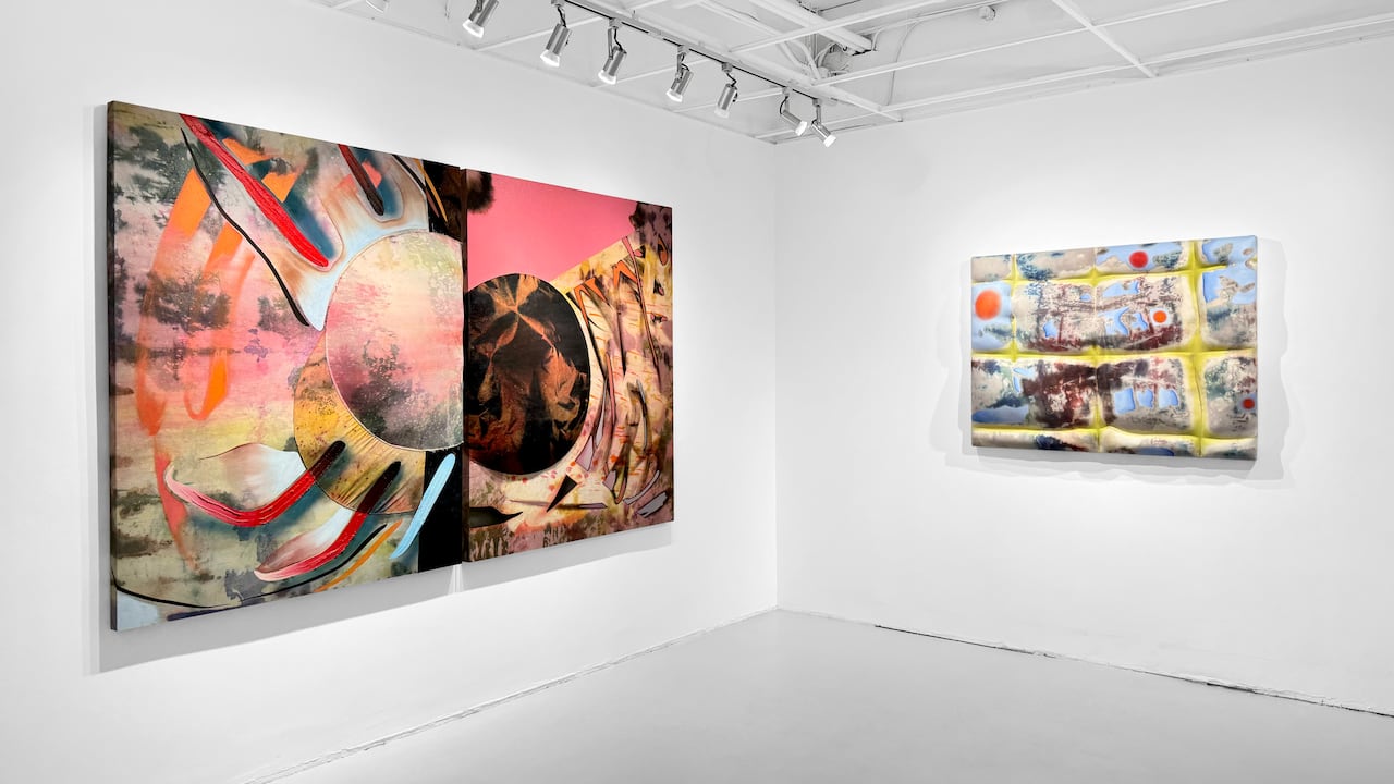 Gallery scene. Two large abstract canvases with are quilted hang on white walls.