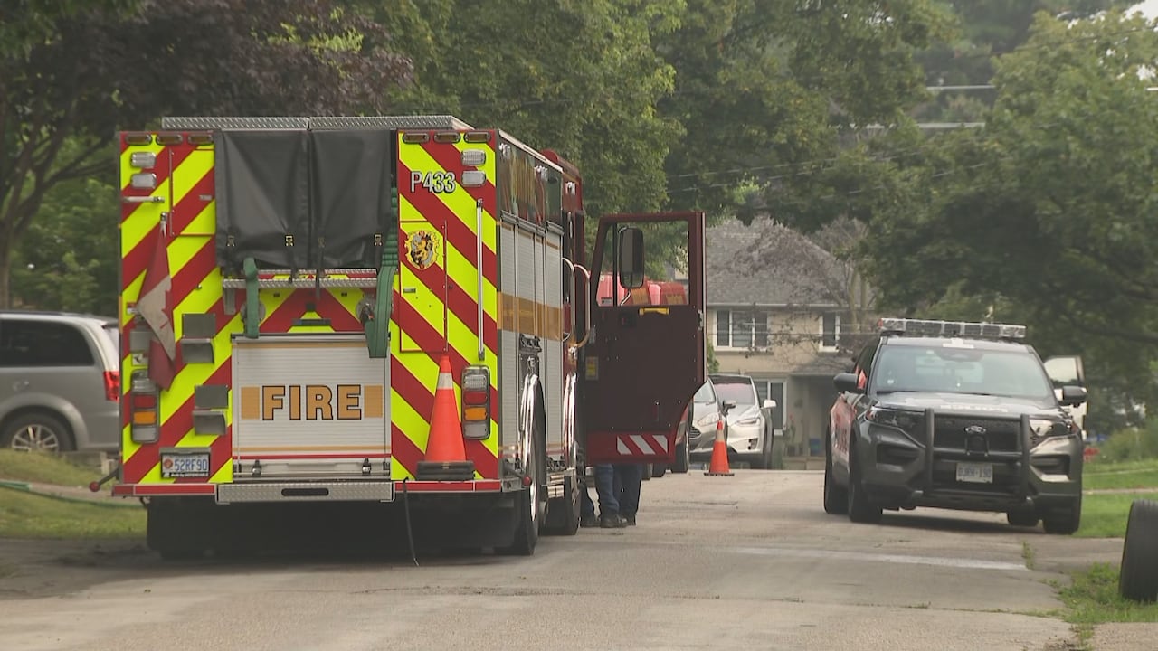 Firetruck and police vehicle parked in a residential area.