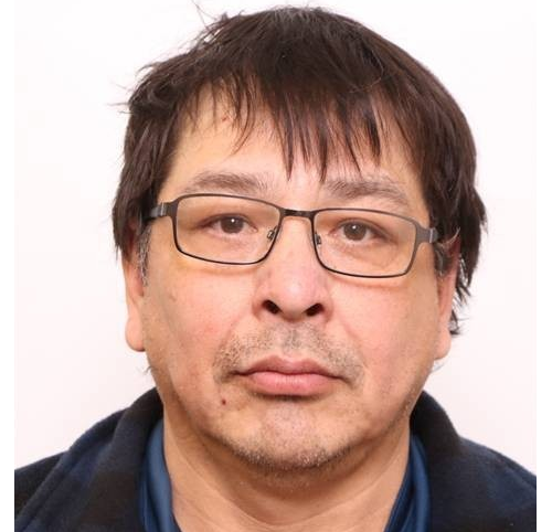 A mugshot of a man with glasses.