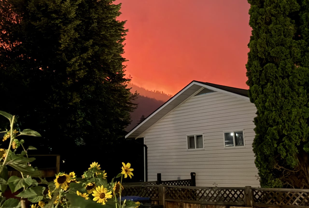 A house is pictured below a red smoky sky.