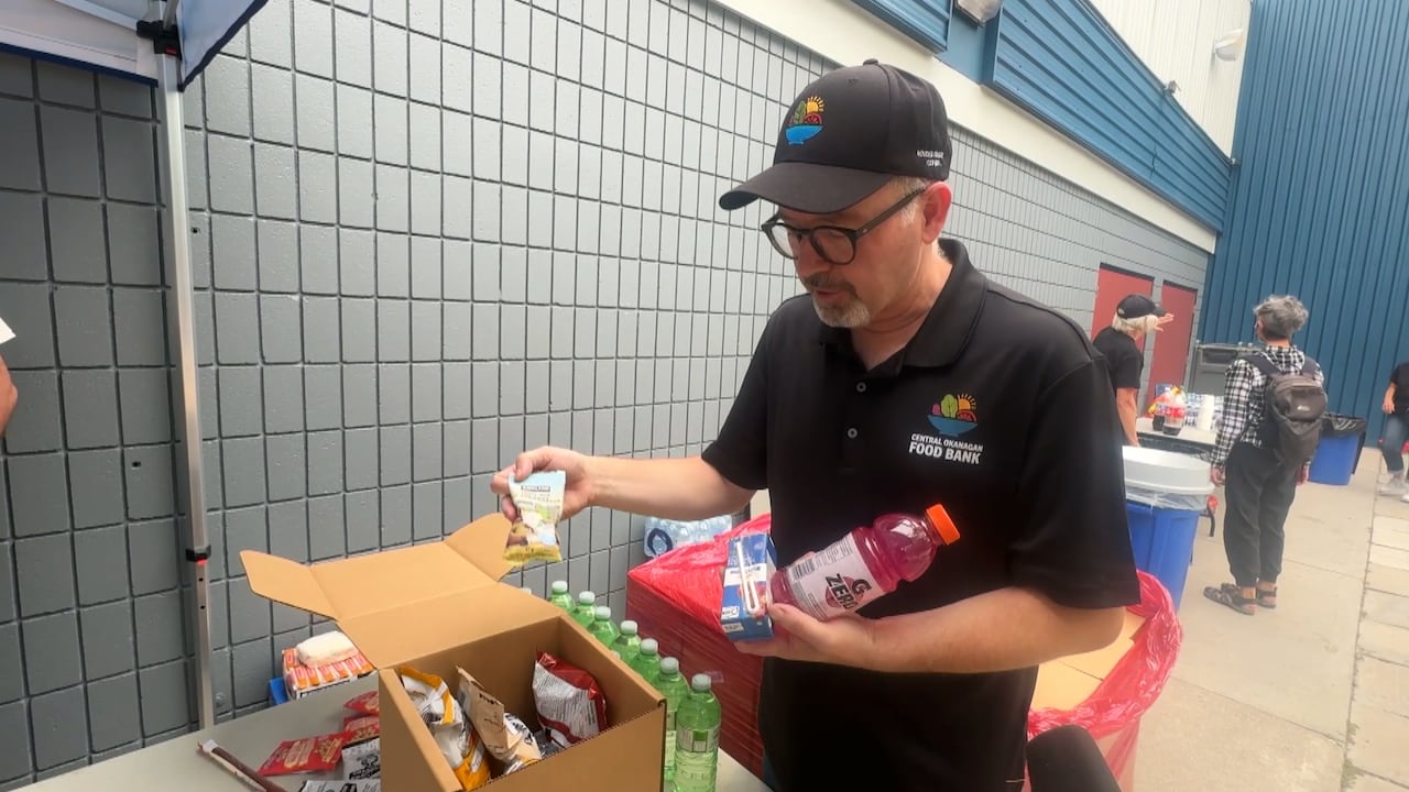 A man lifts food out of a to-go box.
