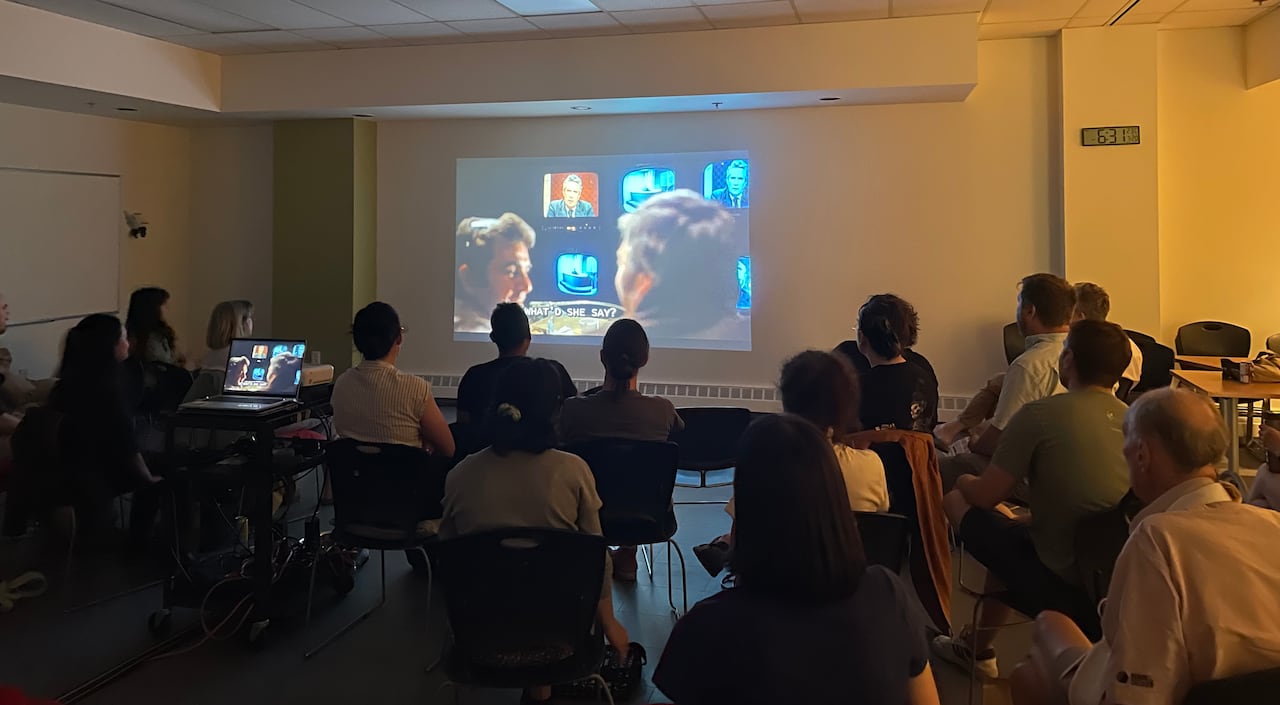 Audience watching classic 1976 movie, 'Network' on a projector.