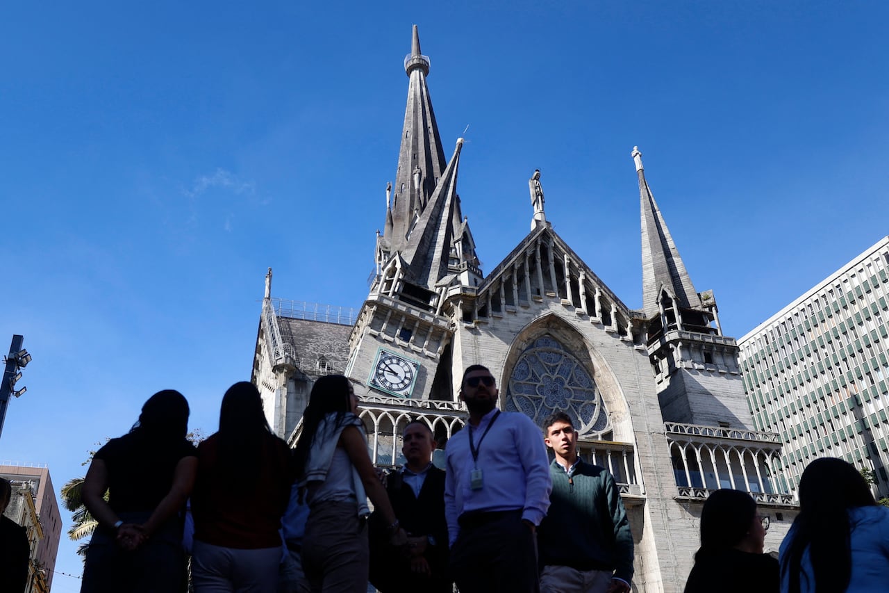 Several people are shown in shadow in the foreground, and in the background a church with a damaged roof and steeple is shown.