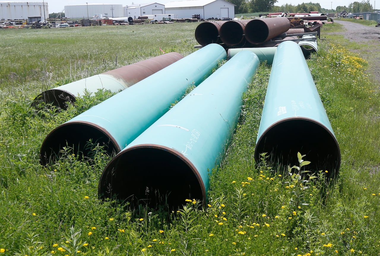 Green pipes lay on grass.
