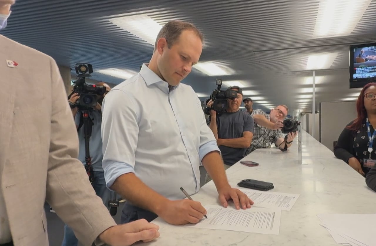 Man signing a form at an office.