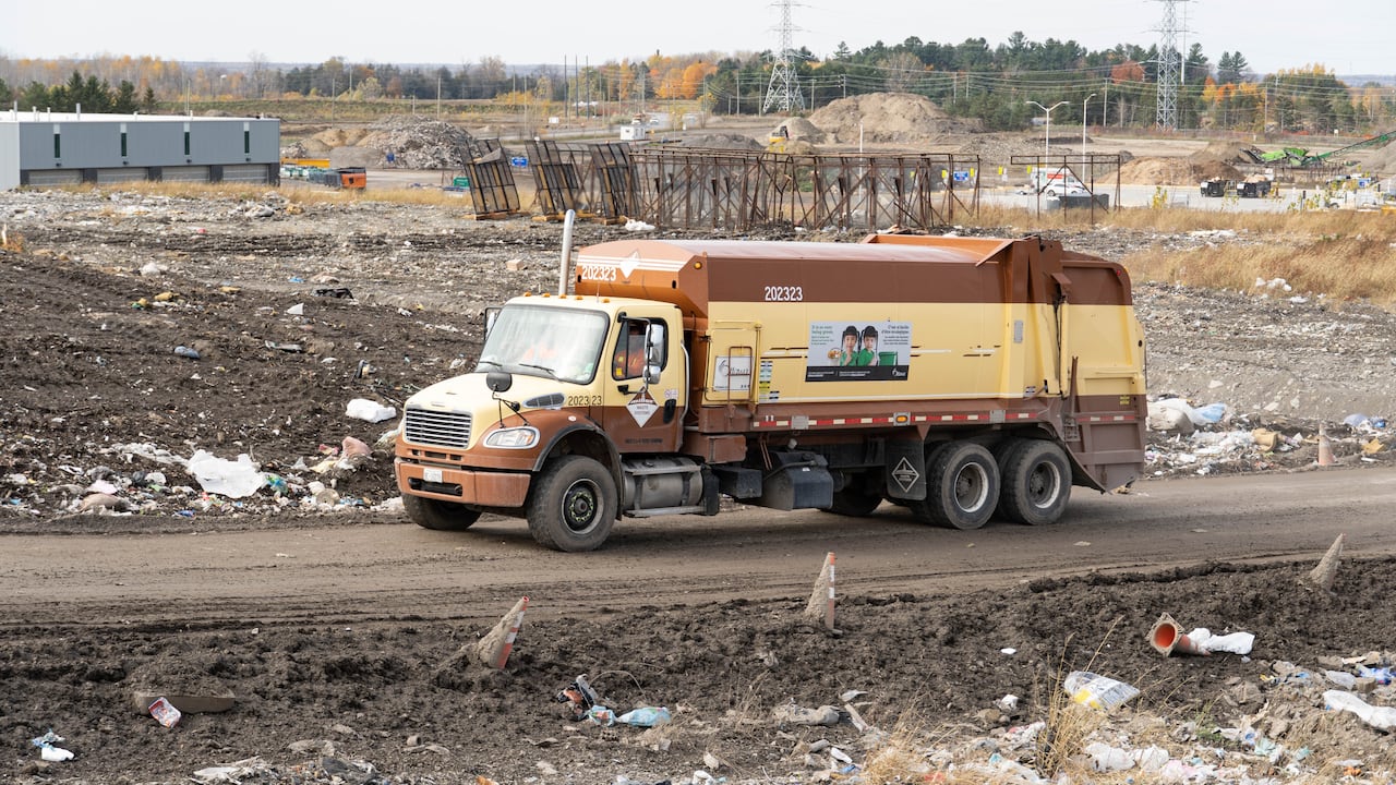 A garbage truck enters a landfill.