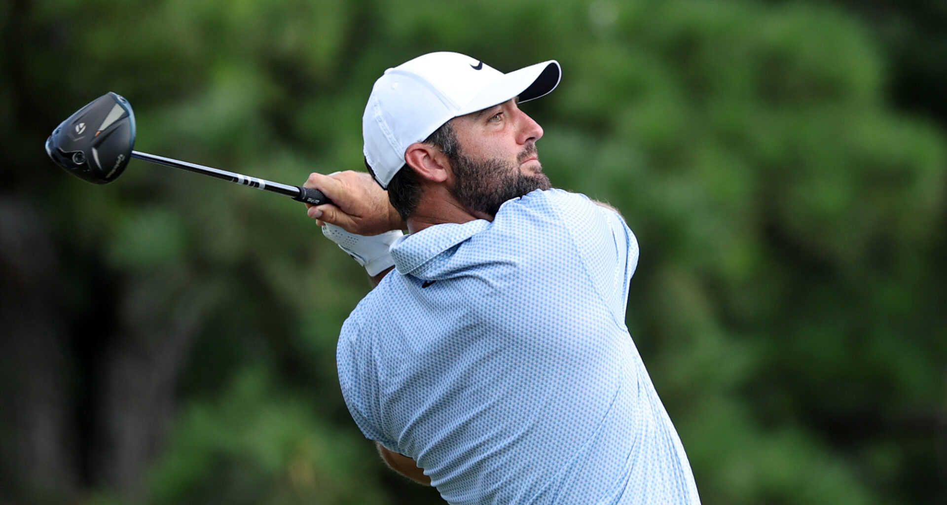 Golfer Scottie Scheffler swinging a club.