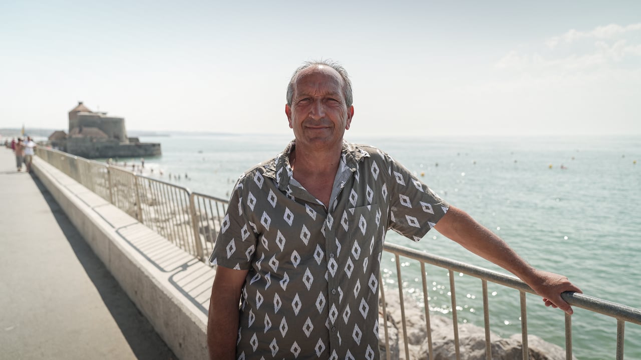A man smiles to camera on a boardwalk.