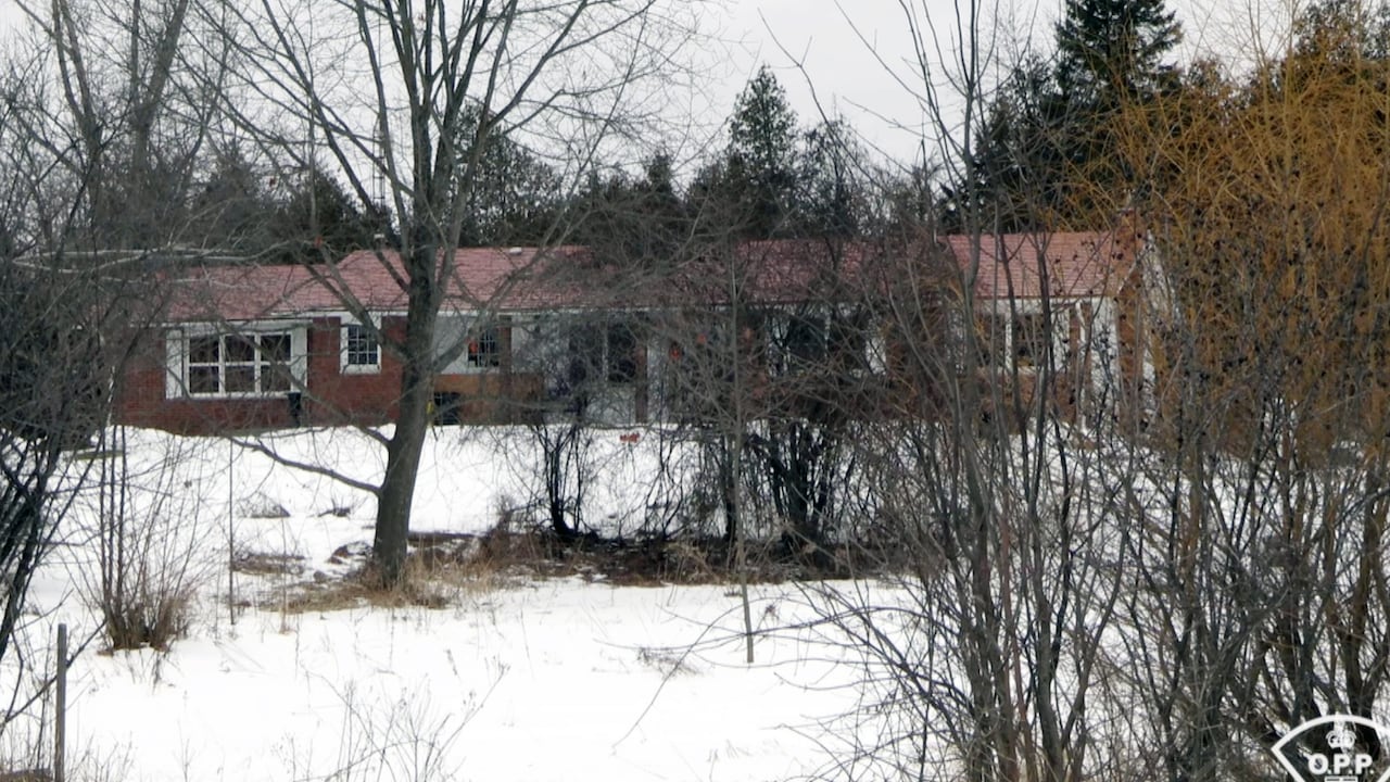 A house in the woods in winter with snow on the ground.