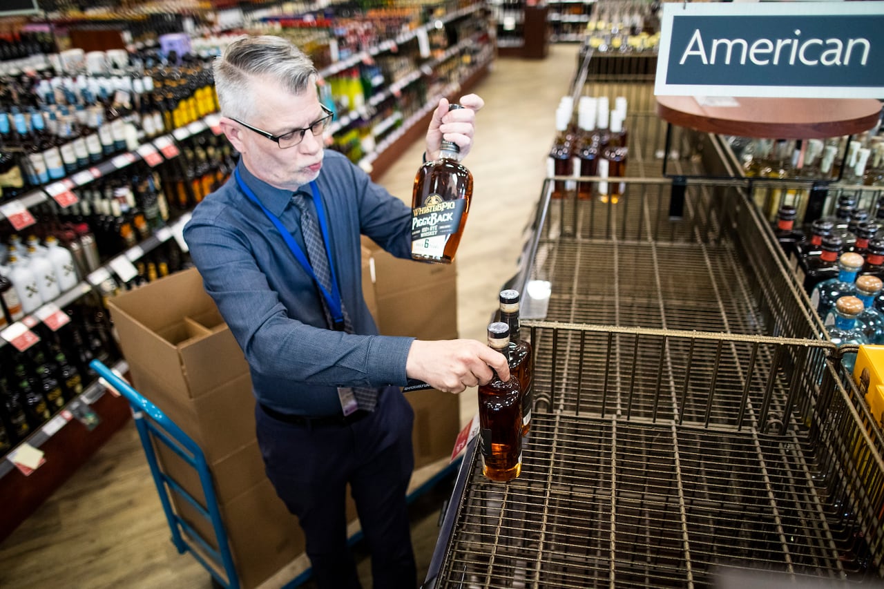 Man removes bottles from a store shelf