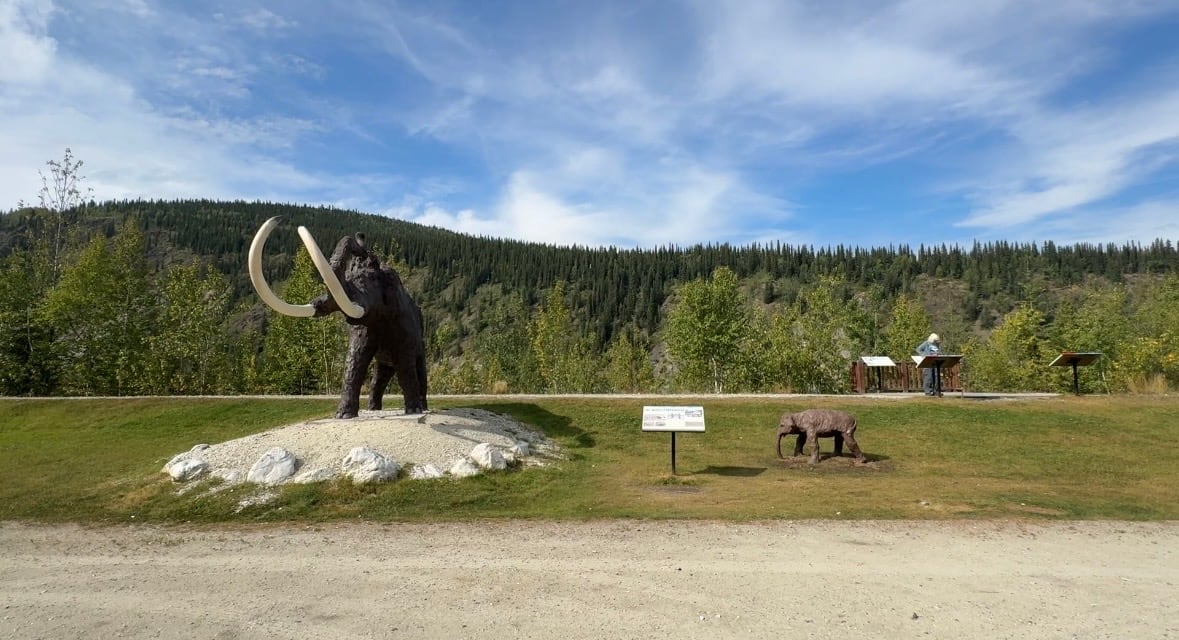 Two statues of mammoths. One large. One small.