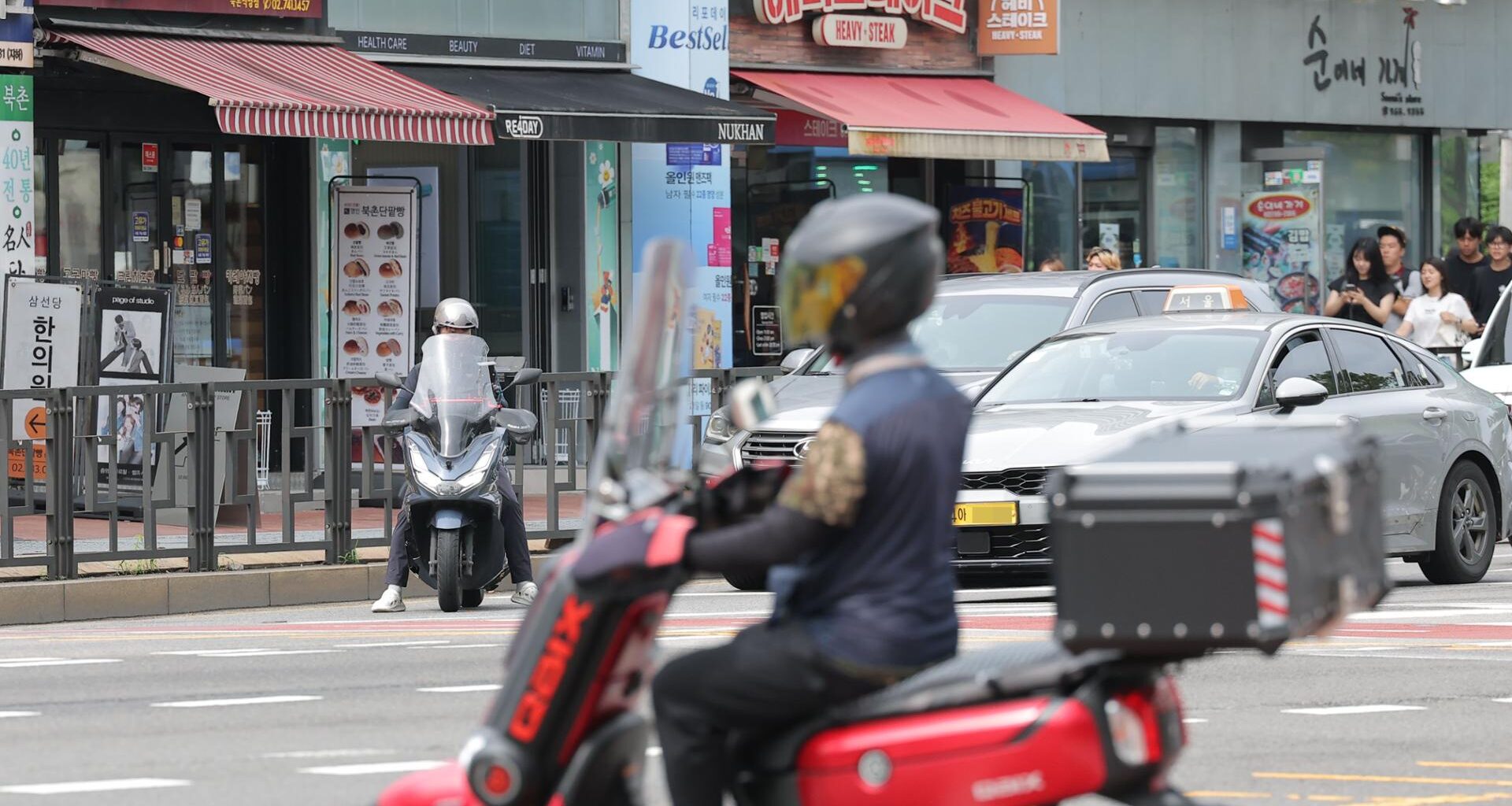 A food delivery worker rides a motorcycle through Seoul, July 8. Yonhap