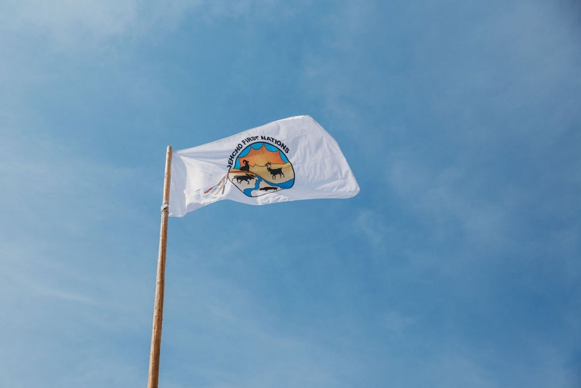 A white flag with logo on a blue sky
