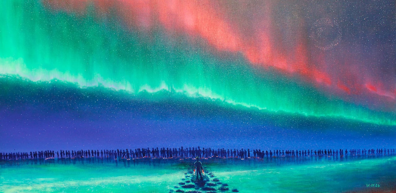 A painting of the northern lights with many people in the distance and a man standing with rocks out in front of him.