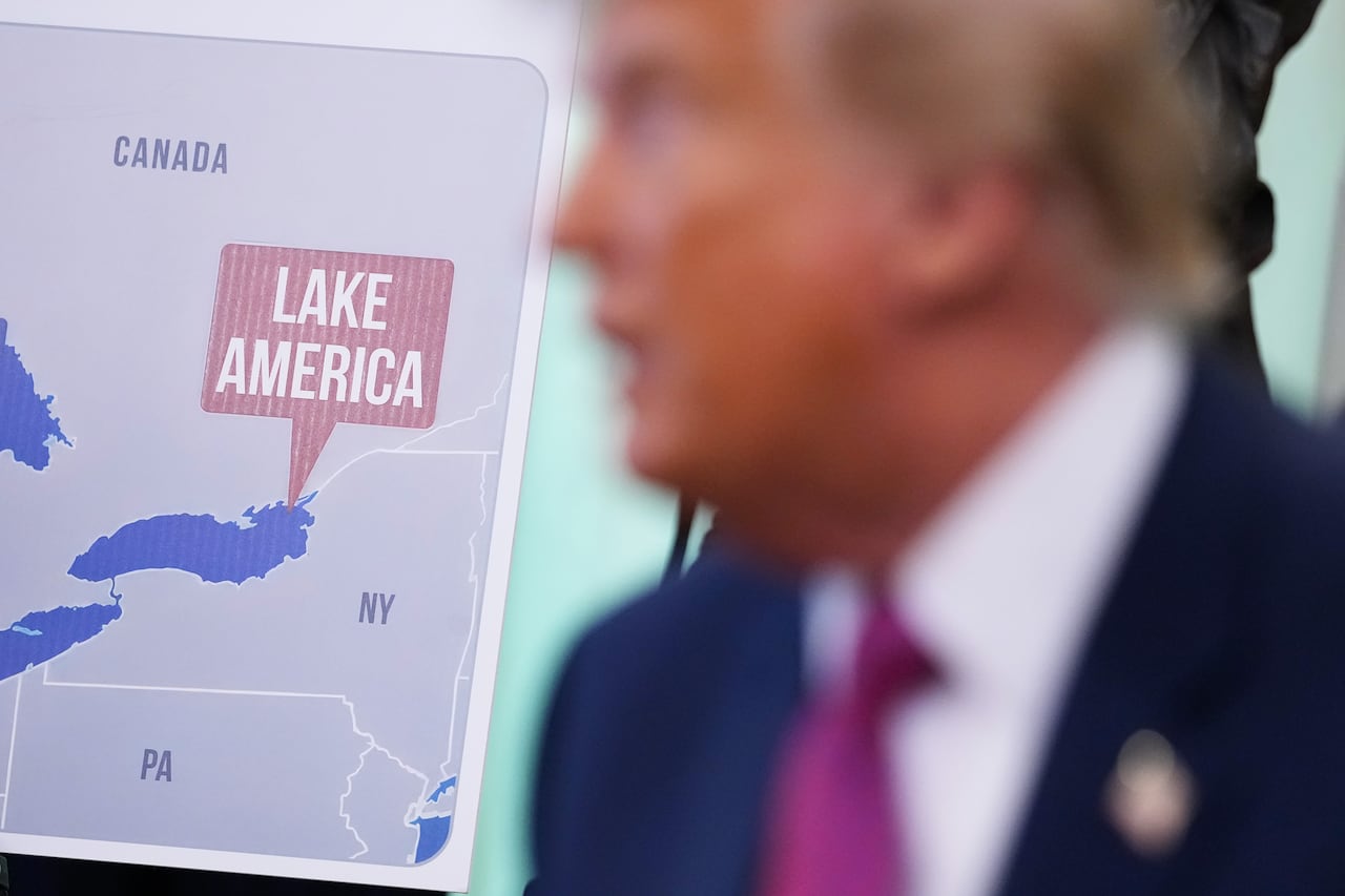 A person is seen in front of a map.