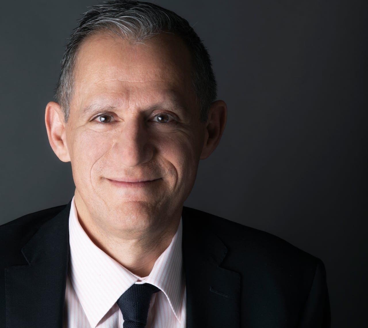 A head and shoulders image of a man with a suit and tie.