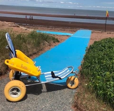 a long blue mat leading out to a beach