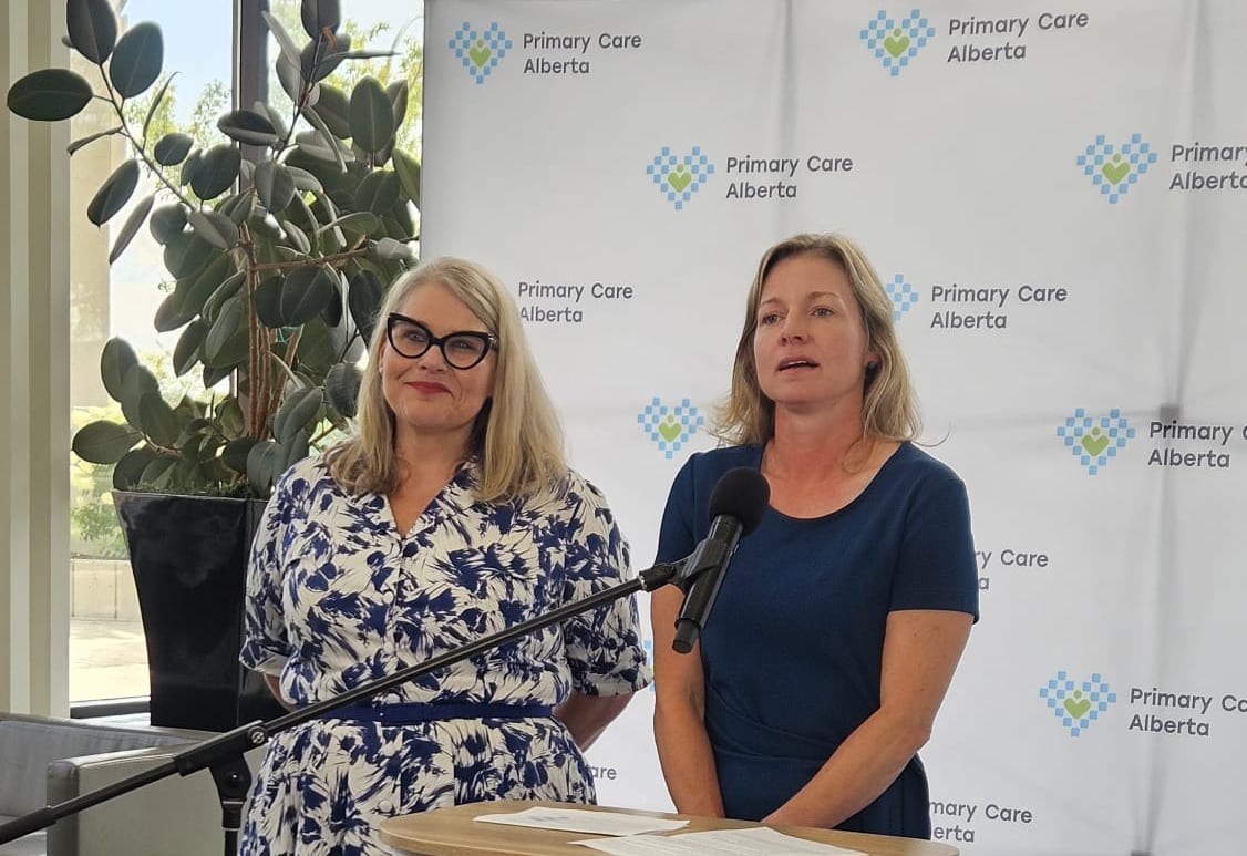 Two women stand at a podium.