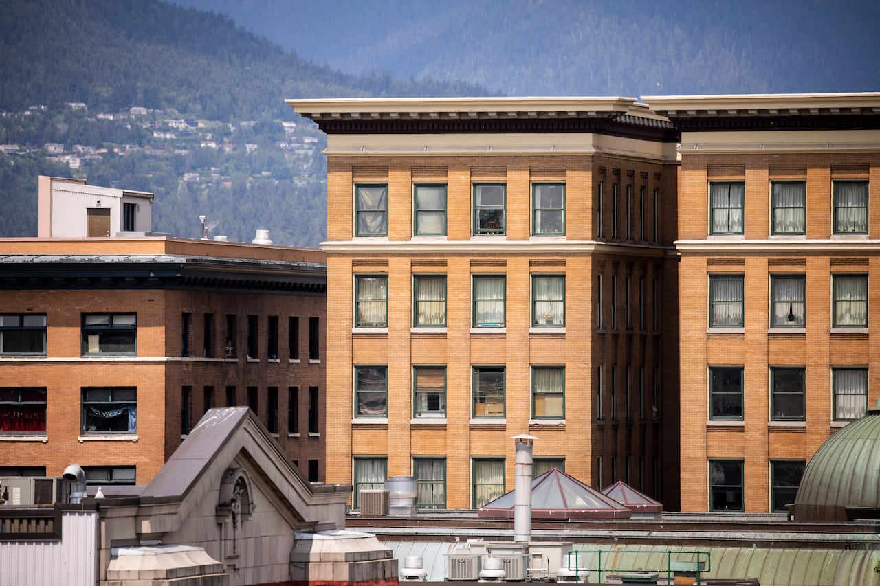 Historic buildings are seen with mountains in the background.