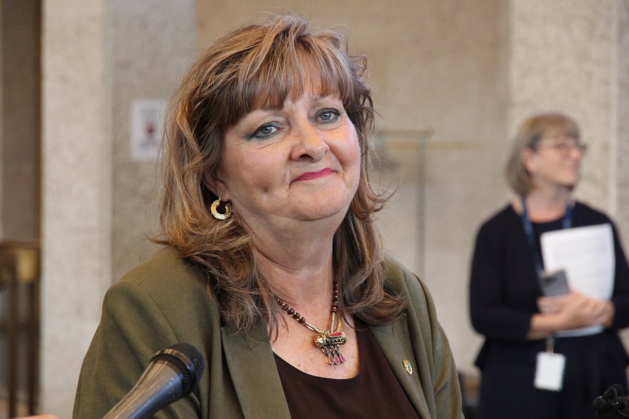 A woman is standing in front of a microphone.