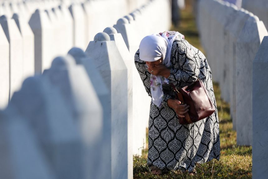 A Bosnian Muslim woman reacts amid grave stones of victims killed during the Srebrenica genocide, at the Srebrenica Genocide Memorial in Potocari, Bosnia and Herzegovina, July 11, 2025.