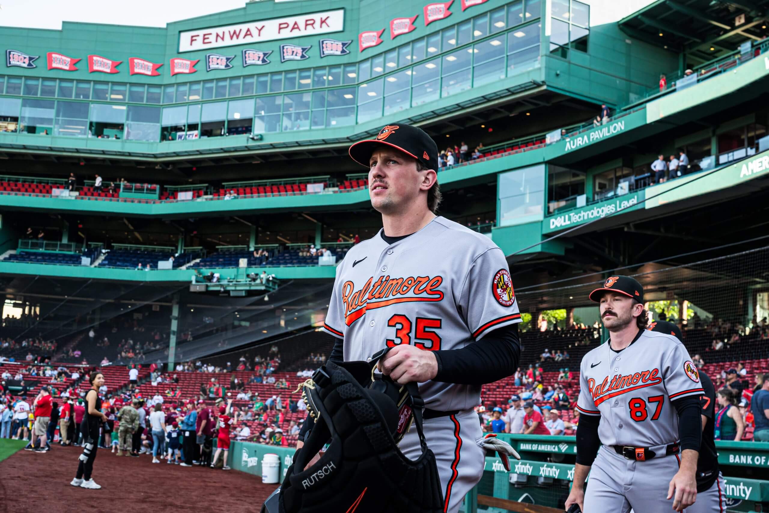 Baltimore Orioles catcher Adley Rutschman (35) and field coordinator/catching coach Joe Singley (87) walk to the bullpen before the start of the game against the Boston Red Sox at Fenway Park.