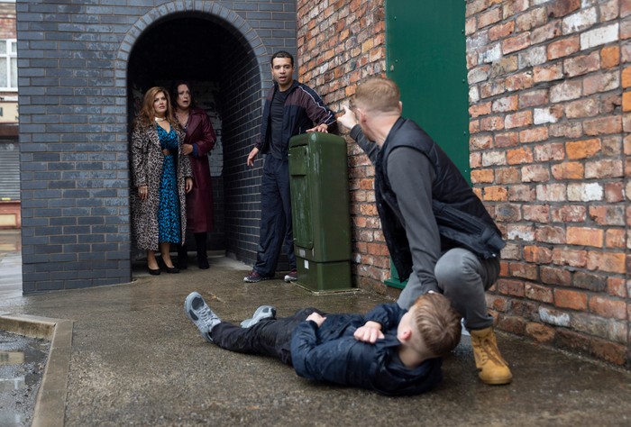 25_08_coro_jake_christina_ollie_04 Gary warns Ollie to stay away from Jake, who lies on his back in the ginnel as Christina and Glenda look on horrified