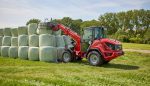 Weidemann 2060T with telescoping in a field lifting bales.