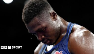 Dimeji Shittu, wearing a blue vest, looks down
