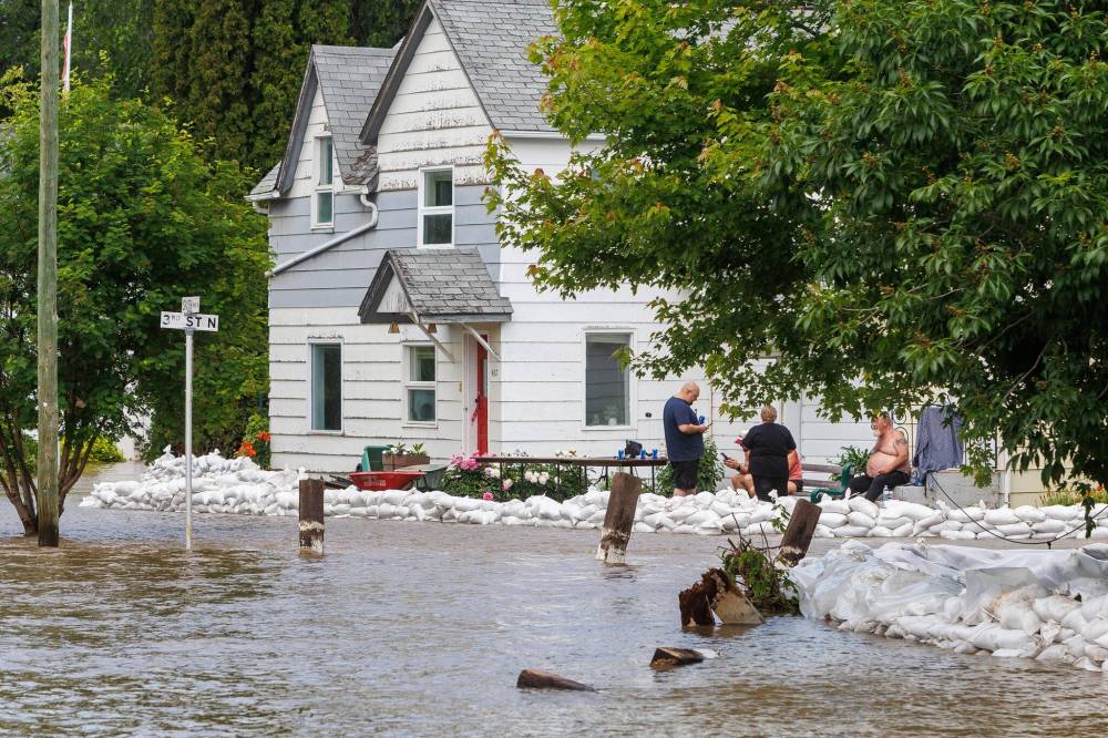 Mike Deal / Free Press files
People take a break from sandbagging to protect properties in a flooded area of Swan River on July 2.
