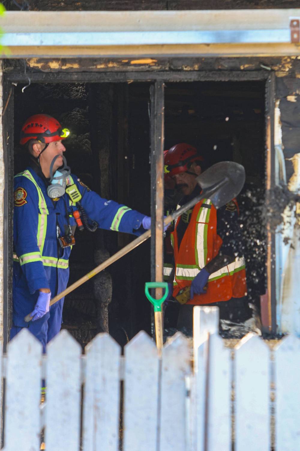 MIKE DEAL / FREE PRESS
Fire investigators dig through debris from the house fire.