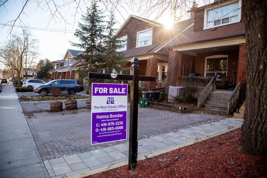 A for sale sign is displayed outside a home in Toronto