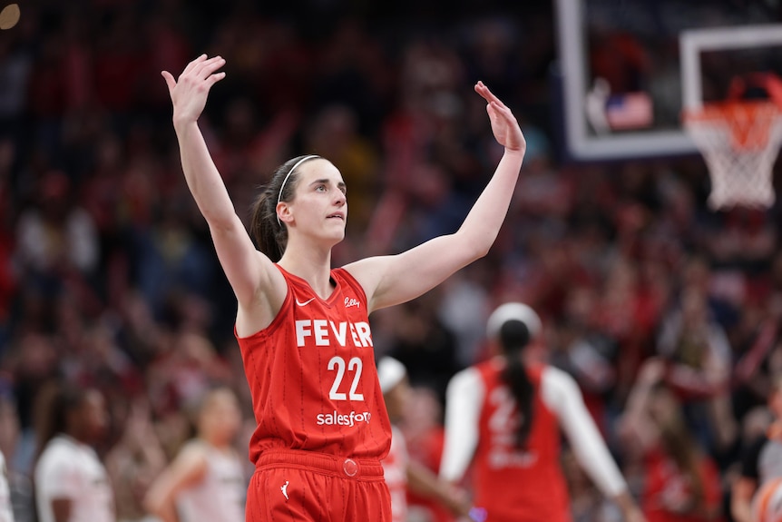 Caitlin Clark lifts her hands up in celebration