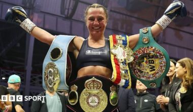 Ellie Scotney smiles and stretches her arms wide as she shows off the WBO, WBA, IBF and WBC super-bantamweight belts