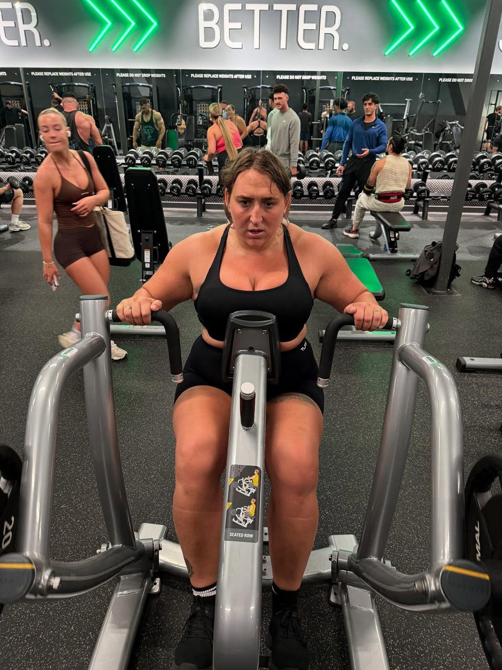 person using a seated row machine in a gym. person using a seated row machine in a gym.