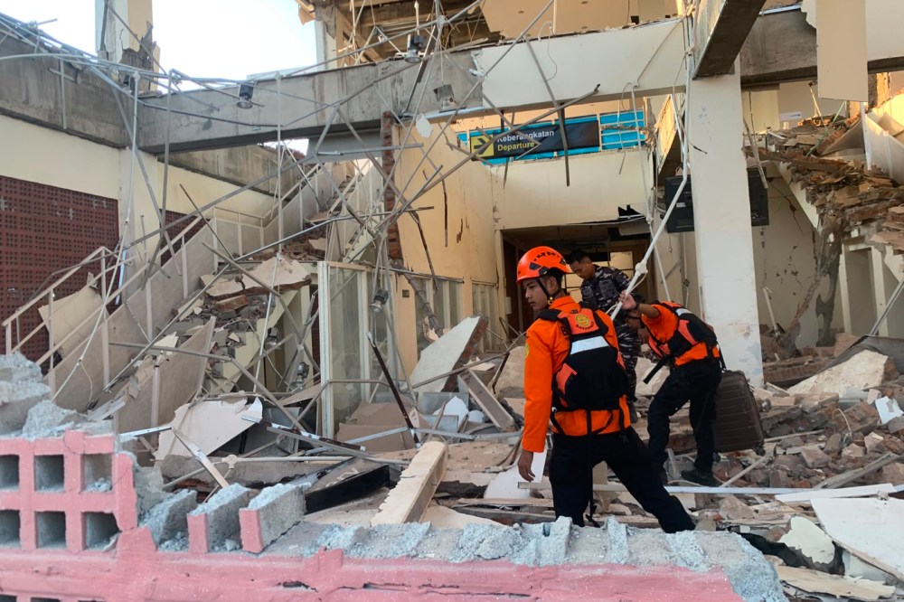 In this photo released by the Indonesian National Search and Rescue Agency (BASARNAS), rescuers search for victims at a damaged building following an earthquake in Maumere, East Nusa Tenggara Province, Indonesia, Saturday, Aug. 15, 2026. (BASARNAS via AP)