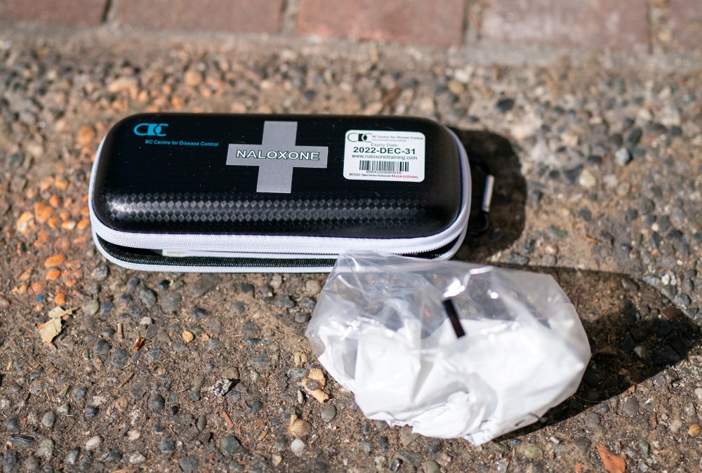 A used naloxone kit is seen on the sidewalk as paramedics respond to a drug overdose in downtown Vancouver on June 23, 2021. THE CANADIAN PRESS/Jonathan Hayward