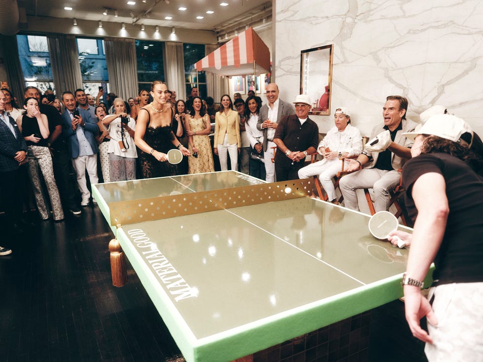 A lively table tennis match with a crowd cheering at a stylish event, featuring players and spectators enjoying the game.