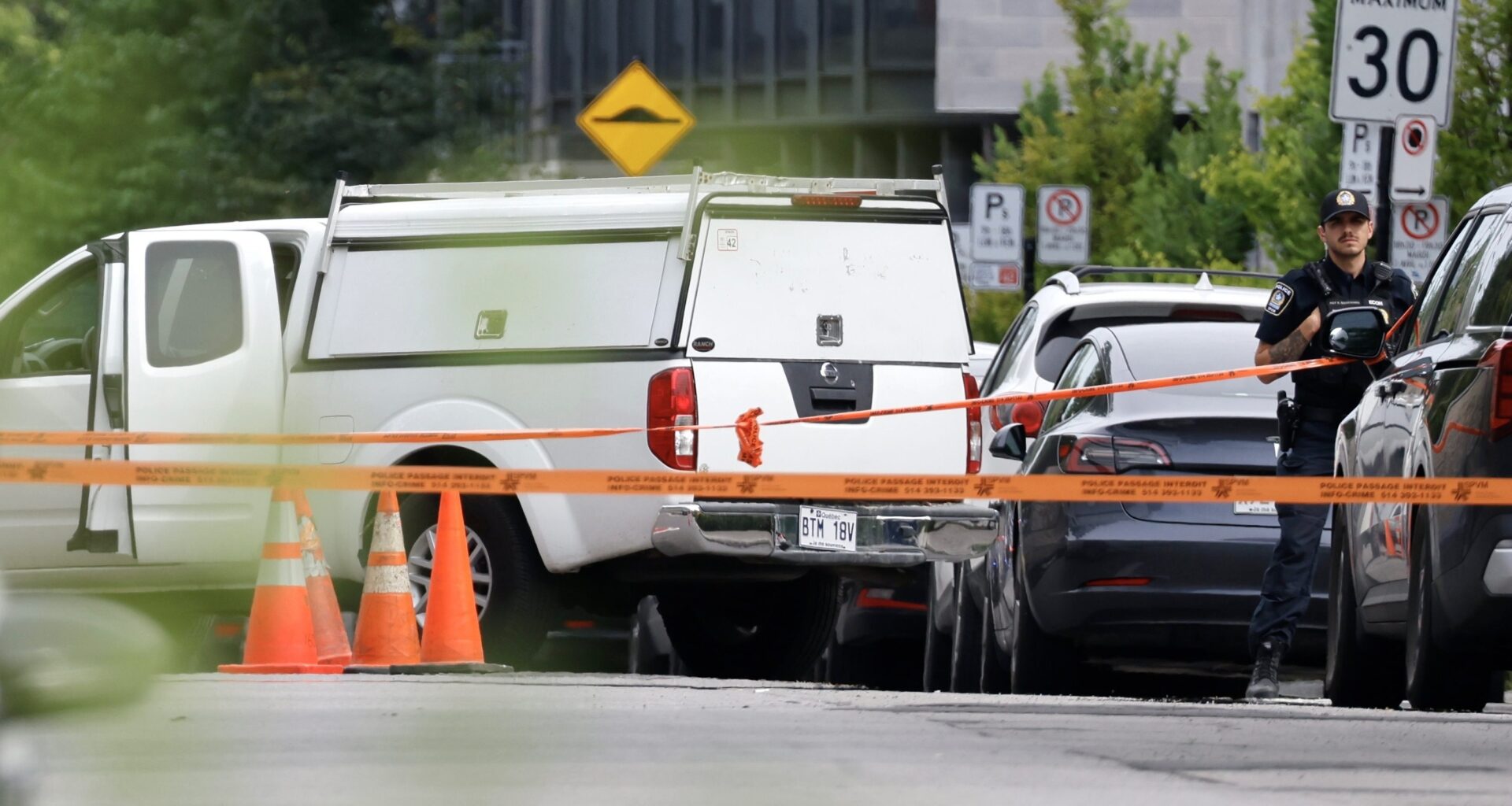 A white pickup truck and police vehicles are behind orange crime-scene tape.