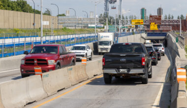 Traffic goes through a construction site near the mouth of a tunnel.