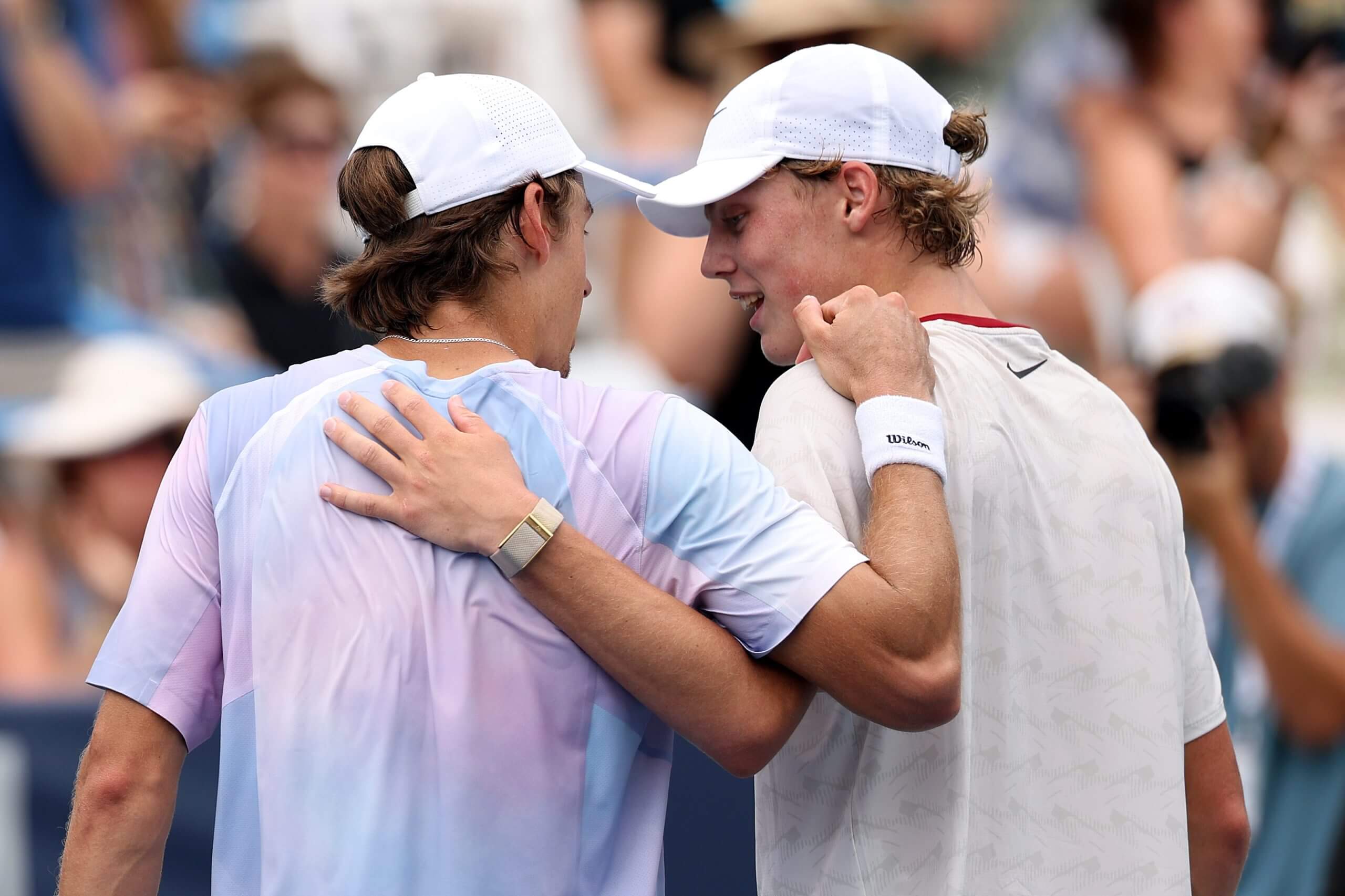 Alex de Minaur (left) and Cruz Hewitt (right) embrace at the end of a tennis match.