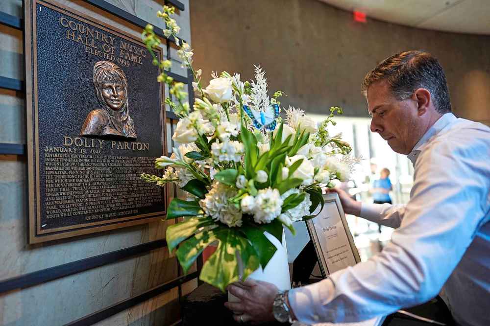 Flowers are placed near Dolly Parton's plaque at the Country Music Hall of Fame on Tuesday. (AP Photo/George Walker IV)